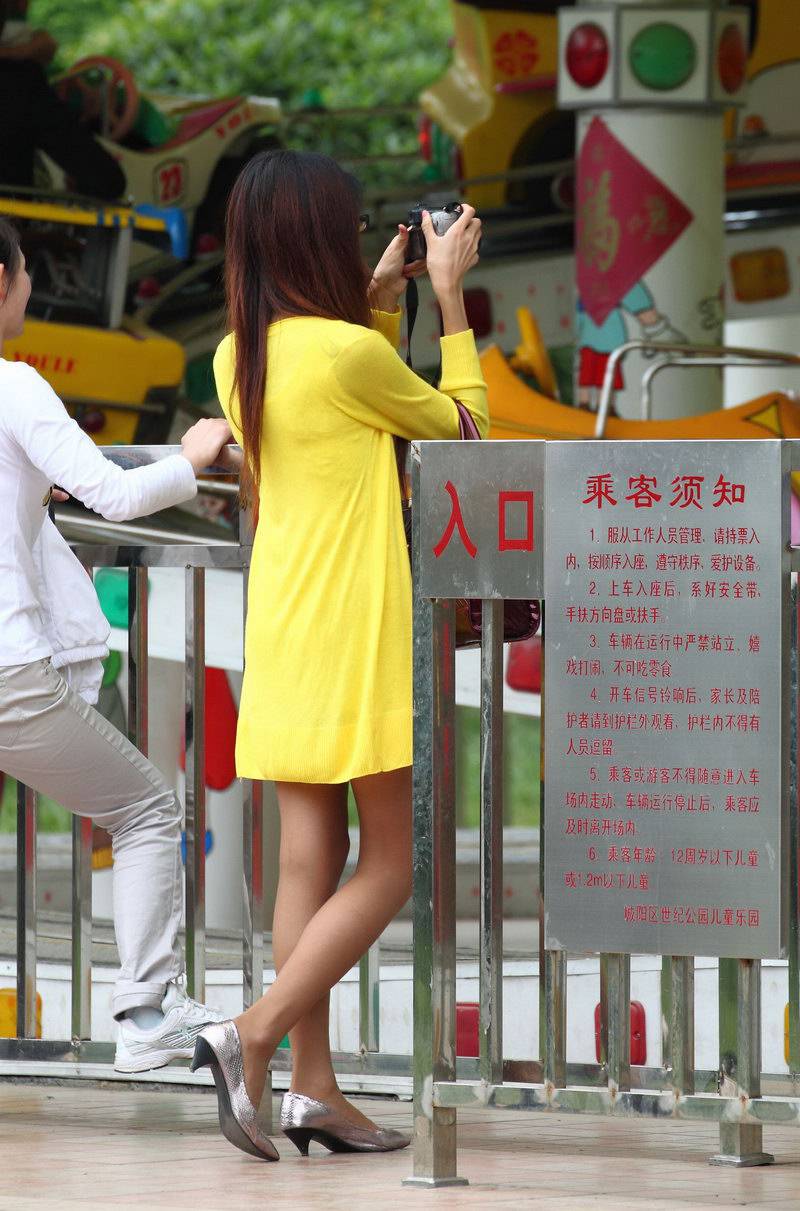 公園里學(xué)習(xí)攝影的街拍美女背影