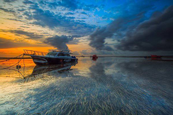 夕陽下海灘小船唯美風(fēng)景圖片