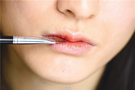 運用唇膏與工具搭配橘紅勾勒性感雙唇